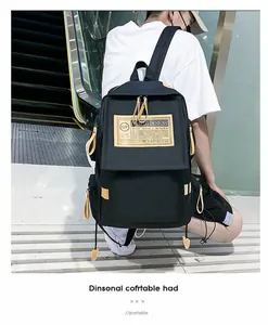 Dettaglio dello zaino in nylon nero con cinghie beige e tasche laterali su una scala mobile