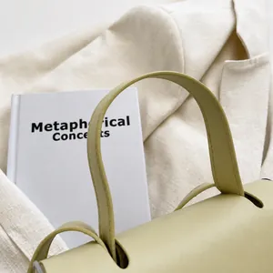 Dettaglio del manico superiore curvo con cuciture rifinite su una borsa Kelly beige
