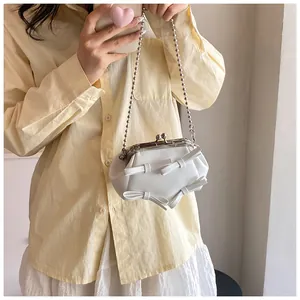 Dettaglio mini borsa bianca con fiocchi, chiusura a sfera argento e tracolla a catenina