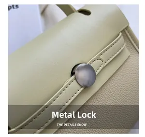 Dettaglio della chiusura in metallo argento su borsa in pelle gialla a contrasto