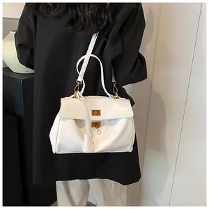 Dettaglio borsa shopper in pelle bianca con chiusura girevole dorata e tracolla