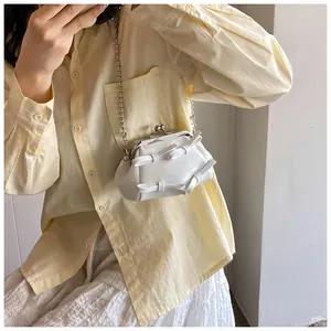 Mini borsa a tracolla bianca con fiocchi e catena a sfere indossata da modella