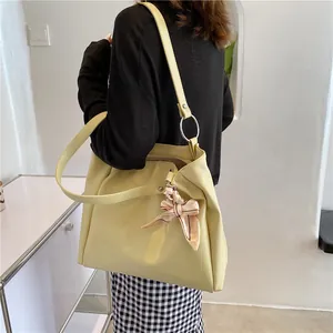 Large cream faux leather tote bag with decorative silk scarf on a metal ring
