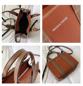 Detail showing two-tone litchi pattern leather with white stitching and silver logo