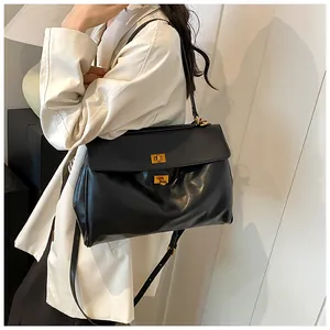 Dettaglio della borsa tote in pelle nera lucida con due chiusure a scatto in metallo dorato