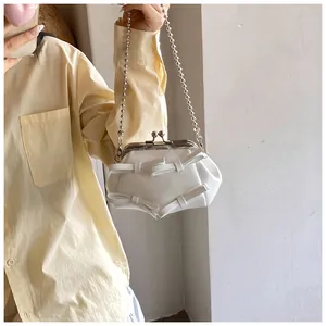 Dettaglio della mini borsa bianca con fiocchi e tracolla a catena con sfere argento