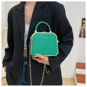 Detail of green hexagonal acrylic crossbody bag with gold metal trim and woven handle