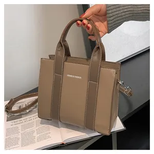 Detailed view of brown lychee grain leather tote bag with white contrast stitching