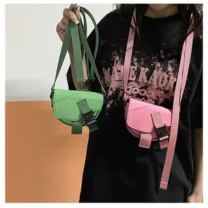 Dettaglio di mini borse a sella in nylon verde e rosa con chiusura a fibbia a scatto