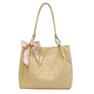 Chic beige crocodile texture tote bag with a pink silk bow and silver hardware