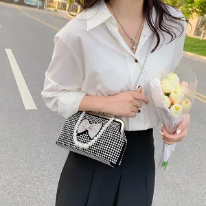 Elegant rhinestone evening bag with large crystal bow and pearl handle for formal events