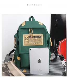 Dettaglio dello zaino in tela verde che mostra la grande capacità con un tablet