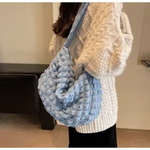 Détail du tissu à bulles bleu clair et de la fermeture éclair métallique du sac à main