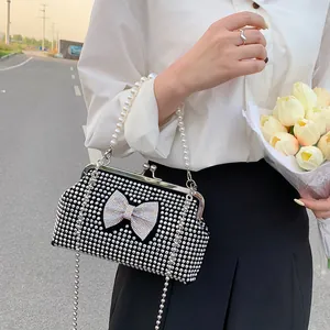 Fashionable women's evening handbag with pearl handle and sparkling bow design