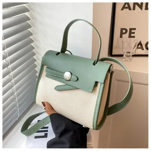 Dettaglio della borsa stile Kelly bicolore con pelle testurizzata e finiture in metallo