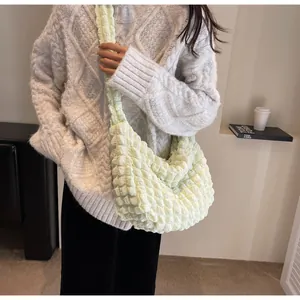 Détail du sac bandoulière vert clair à texture popcorn avec tissu plissé et sangle