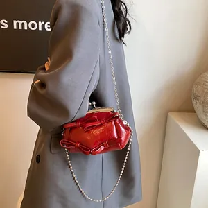Borsa a tracolla rossa retrò con fiocchi e catena d'argento indossata dalla modella