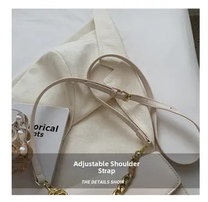 Detail of adjustable beige leather strap with gold chain and metal buckle on women's bag