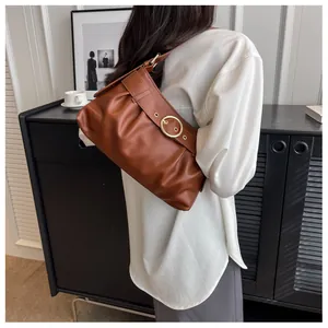 Borsa a spalla arricciata marrone con fibbia in metallo dorato vista da un'angolazione laterale