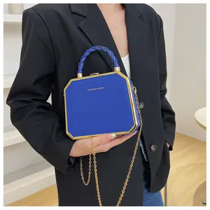 Octagonal blue hard shell crossbody bag with gold metal frame and fashion text logo