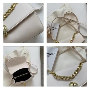 Detail of off-white leather bag with gold chain and internal zipper pocket view
