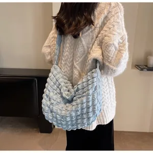Détail du sac à bandoulière bouffant bleu clair avec texture 3D plissée et matière douce