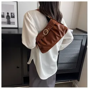 Dettaglio della borsa in ecopelle marrone arricciata con fibbia ad anello in metallo