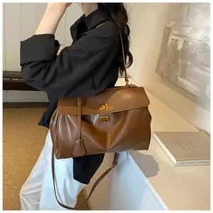 Dettaglio borsa a tracolla marrone vintage con doppi fermagli girevoli dorati e pelle