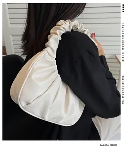 Fashionable creamy white pleated underarm bag with soft PU leather on a model shoulder