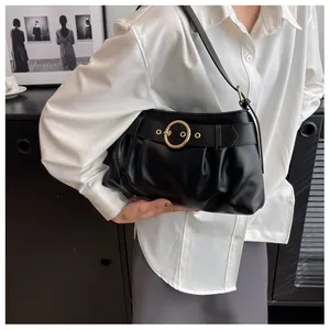 Dettaglio della borsa a spalla nera con design arricciato, anello dorato e cinturino decorativo