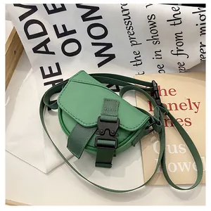 Dettaglio della mini borsa a tracolla in nylon verde con fibbia nera e tessuto tattile