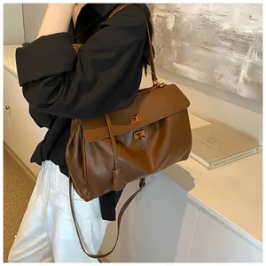 Dettaglio borsa tote in pelle marrone con chiusura a rotazione vintage e design laterale a pieghe