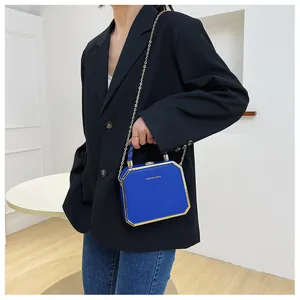 Detail of royal blue acrylic octagon box bag with gold metal frame and fashion logo
