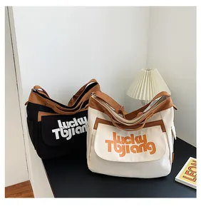 Dettaglio di grandi borse a tracolla in tela nera e beige con stampa lucky TUJIANG