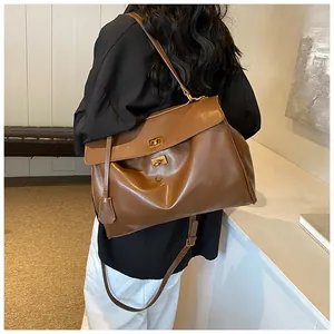 Dettaglio della borsa tote marrone retrò con finitura liscia e chiusure dorate
