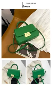 Close-up of vibrant green handbag with woven handle and gold lock mechanism