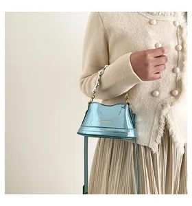 Dettaglio mini borsa a secchiello in pelle verniciata azzurra con catena e logo dorato