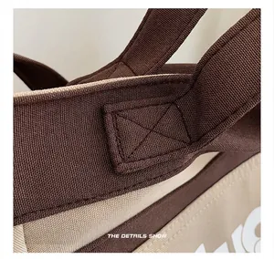 Dettaglio delle cuciture robuste e della trama in tela di una borsa shopper bicolore