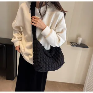 Détail du grand sac cabas plissé noir montrant la texture matelassée sur le sac bandoulière