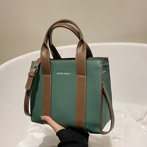 Green lychee pattern leather tote bag with brown straps and adjustable shoulder strap