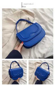 Vista dettagliata della borsa a tracolla in pelle blu con patta ondulata e logo C