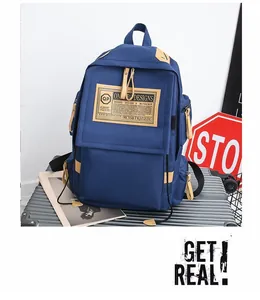 Dettaglio dello zaino in nylon blu scuro su una valigia d'argento con tiranti in pelle