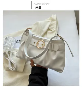 Dettaglio della borsa a pieghe bianco crema con fibbia ad anello dorato centrale e cinturino