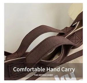 Vista dettagliata dei manici rinforzati e della chiusura lampo della borsa in tela