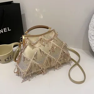 Dettaglio pochette da sera con paillettes color champagne, frange e chiusura in metallo