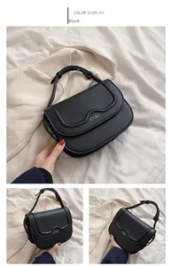Dettaglio di una mini borsa squadrata nera in pelle con logo in metallo e design a onde