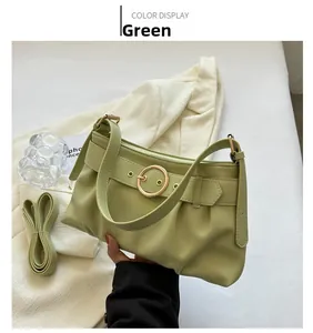Dettaglio di una borsa sottobraccio verde a pieghe con fibbia dorata e trama in pelle PU