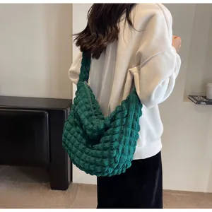 Détail de la texture froncée vert foncé sur le sac à bandoulière chic pour femme