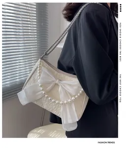 Dettaglio borsa jacquard bianco crema con grande fiocco in organza e perle eleganti