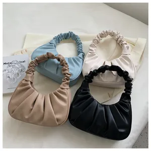 Detailed overhead view of ruched cloud bags in light blue, cream, khaki, and black colors